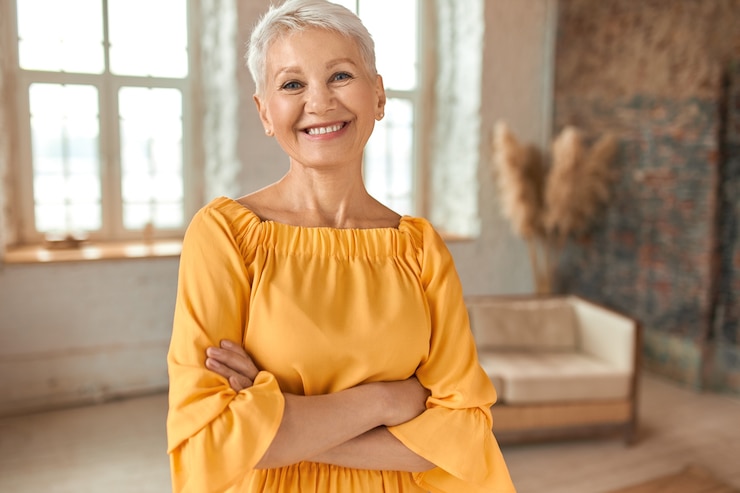 attractive-confident-mature-blonde-woman-wearing-yellow-dress-crossing-arms-chest-smiling-happ...jpg